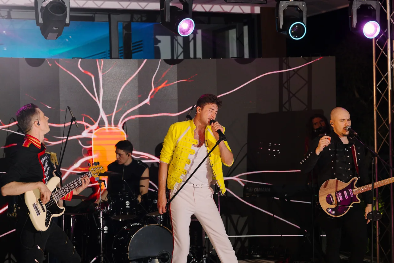 A live band performing under moving lights in front of an LED screen